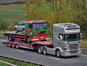 silver scania artic lowloader with flatbed man