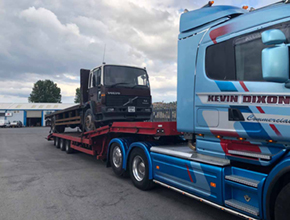 brown volvo flatbed rigid on lowloader