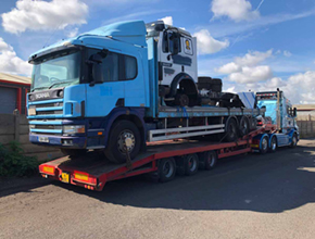 blue scania flatbed rigid on lowloader