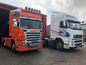 orange scania and white volvo units