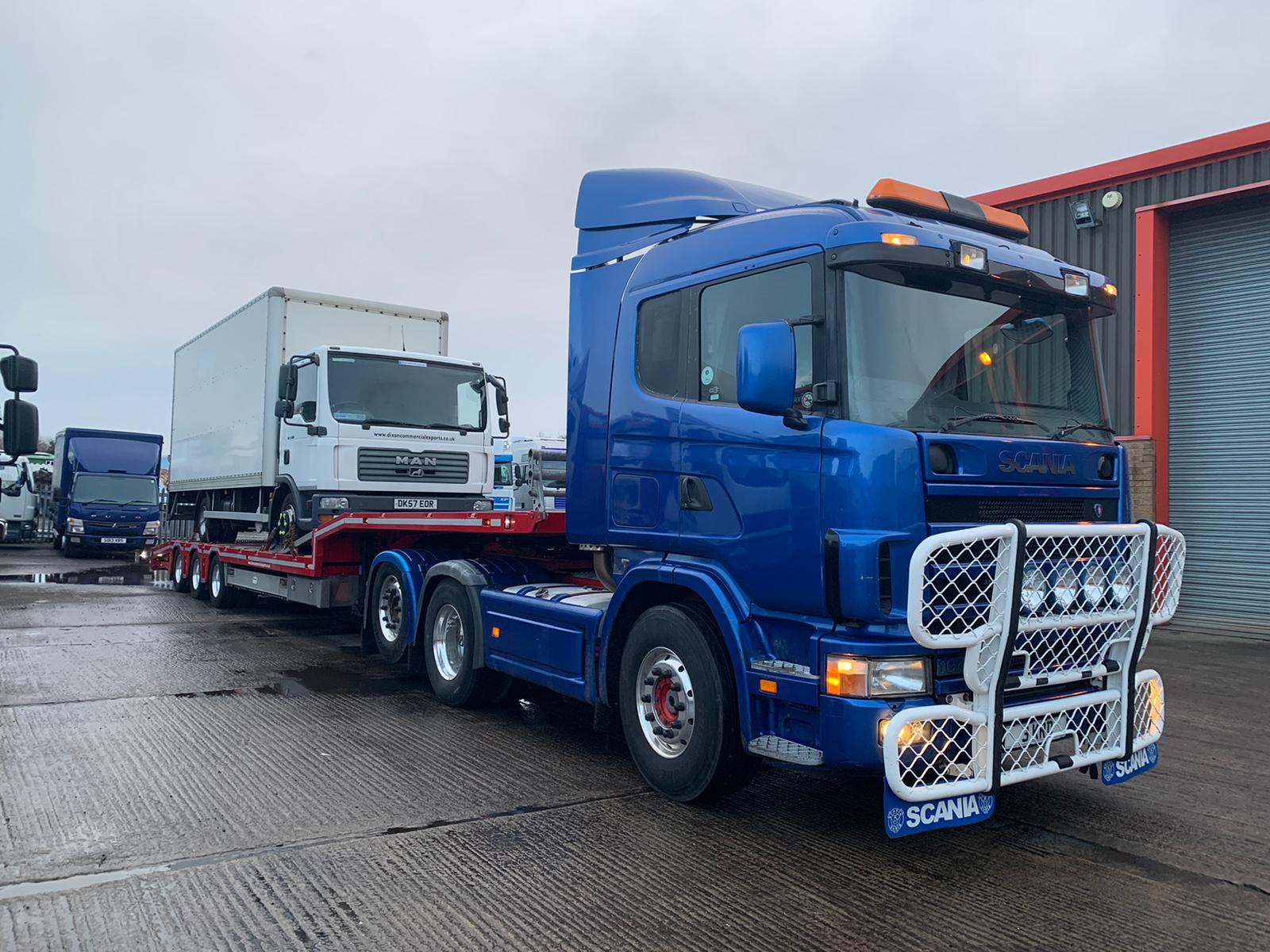 Blue truck carrying wite truck