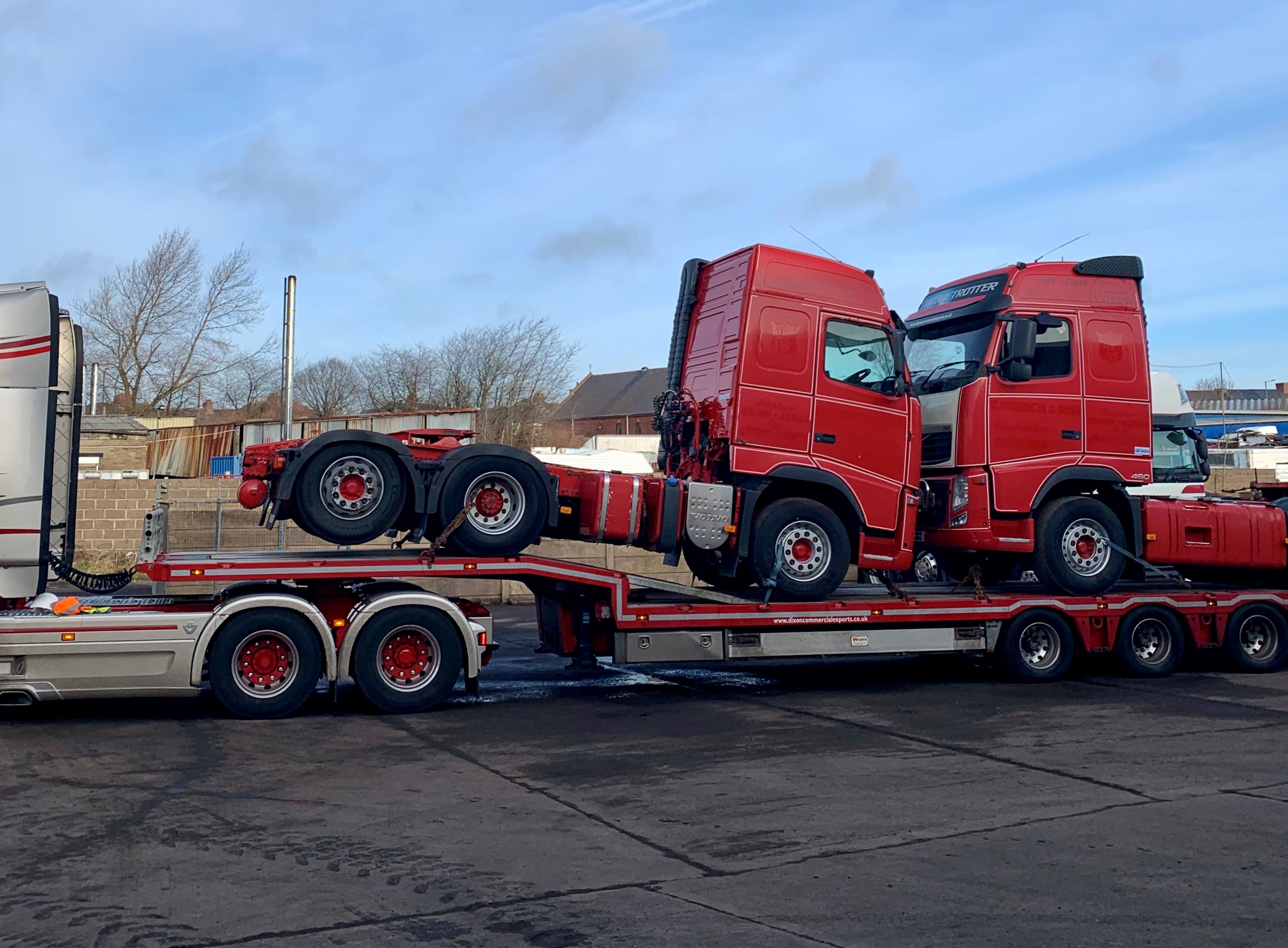 Shiny truck carrying red trucks