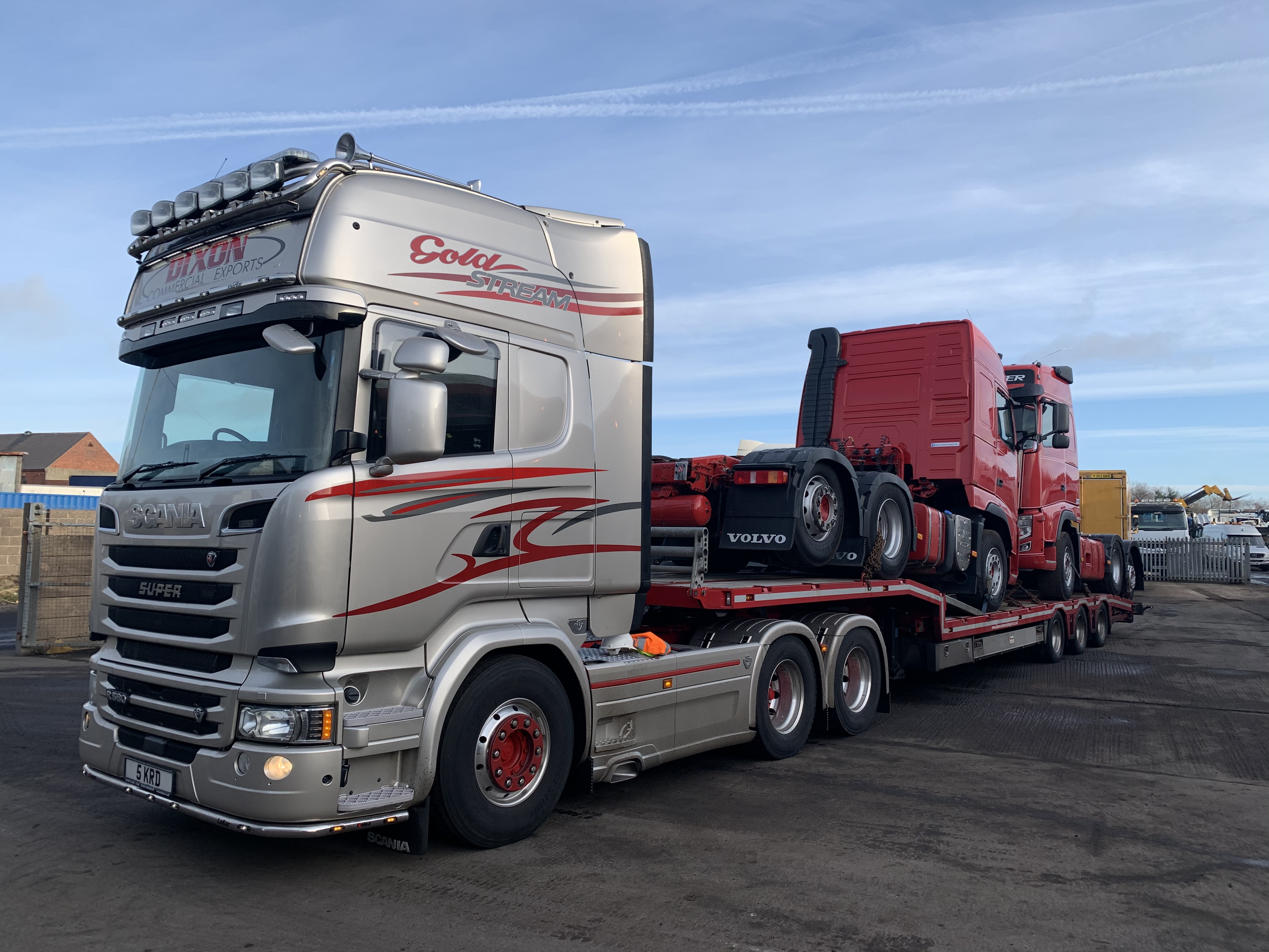 Shiny truck carrying red trucks