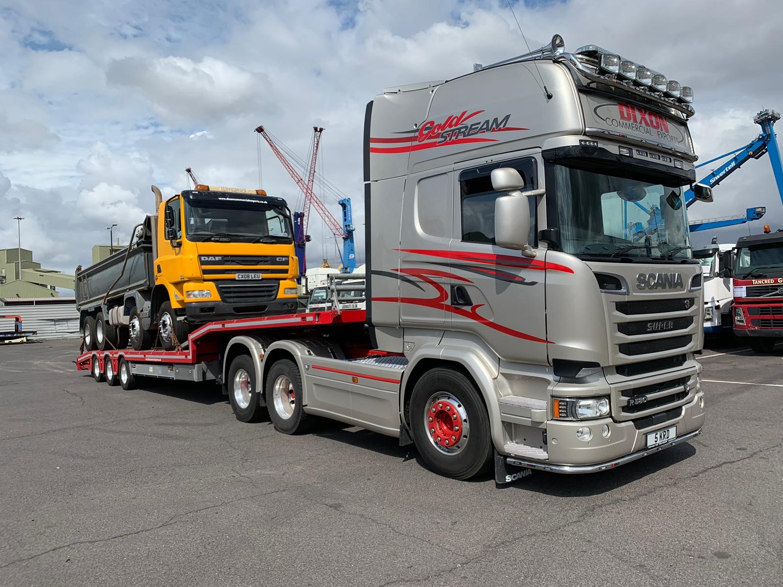 Silver truck carrying yellow truck