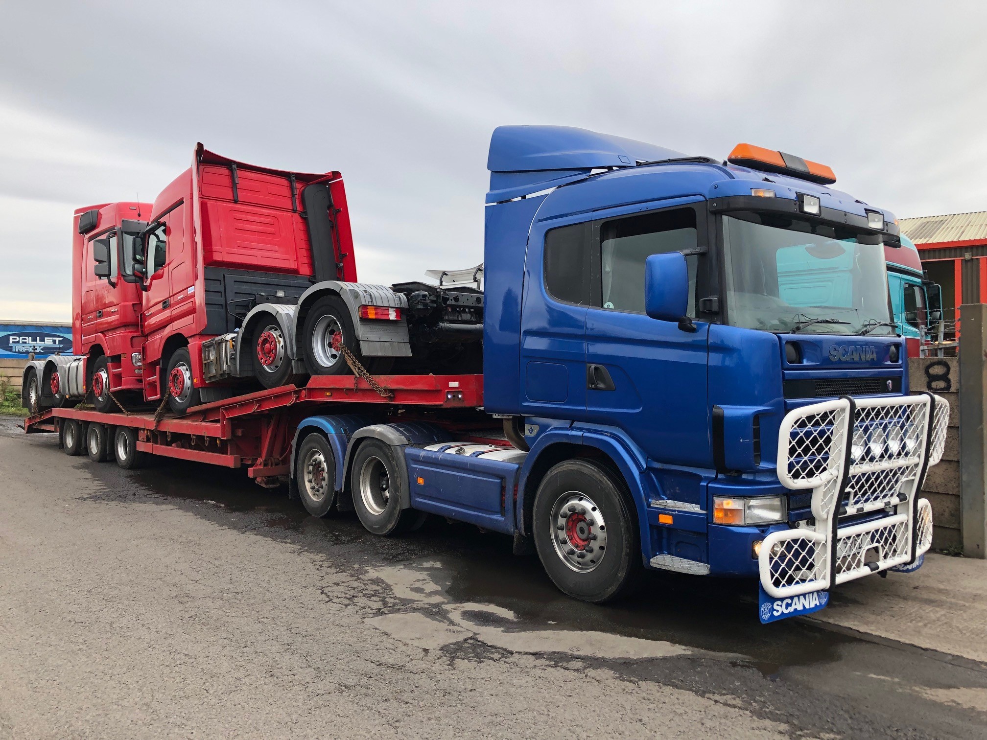Blue truck carrying a red truck