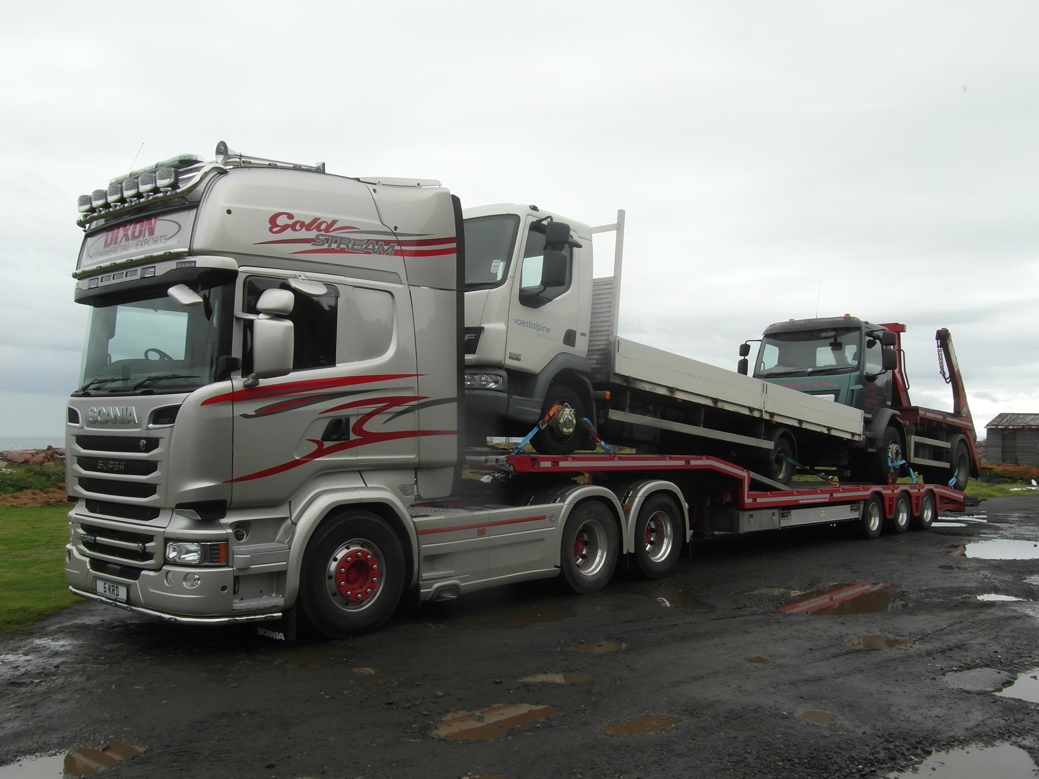 Silver truck carrying a white truck